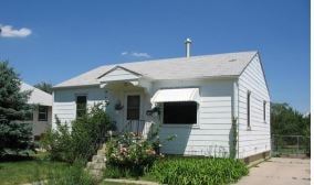 Scottsbluff house for rent - A white house with a grey roof and a chimney.