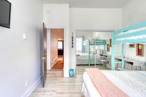 Pagosa Springs apartment for rent - A bedroom with a bed, a TV, and a mirror.