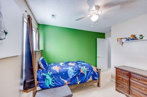 Easley house for rent - A bedroom with a bed, dresser, and a ceiling fan.