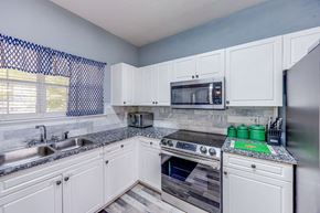 Easley house for rent - A kitchen with white cabinets and a black and white checkered curtain.