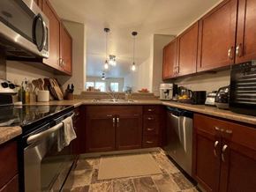 Kapolei apartment for rent - A kitchen with brown cabinets and a tiled floor.