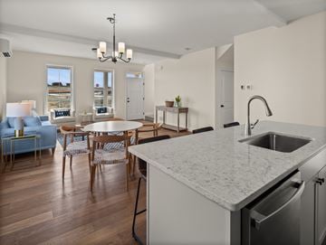 South Burlington apartment for rent - A kitchen with a marble countertop and a dining table with chairs.