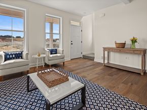 South Burlington apartment for rent - A living room with a white sofa, a white chair, a wooden table, and a large window.