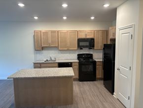 Newark apartment for rent - A kitchen with black appliances and wooden cabinets.