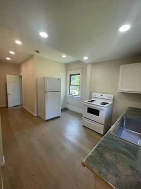 Lima apartment for rent - A kitchen with white appliances and wooden floors.