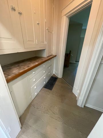 Lima apartment for rent - A kitchen with white cabinets and a wooden countertop.