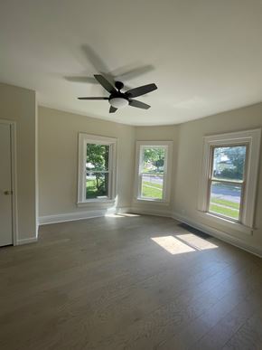 Lima apartment for rent - A room with a ceiling fan and three windows.