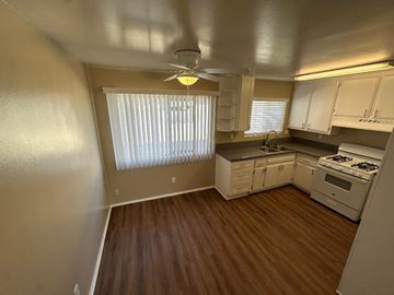 Tustin apartment for rent - A kitchen with white cabinets and a stove top oven.