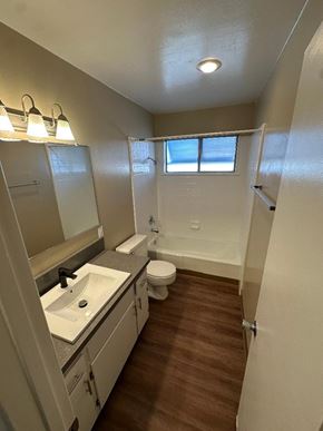 Tustin apartment for rent - A bathroom with a toilet, sink, and mirror.