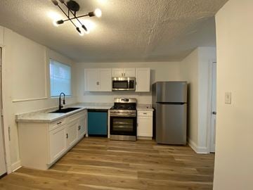 Louisville house for rent - A kitchen with white cabinets and a wooden floor.