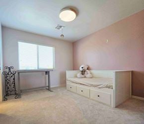 Chandler house for rent - A child's bedroom with a white bed and a window with blinds.