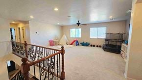 Chandler house for rent - A spacious room with a ceiling fan and a play area with toys.
