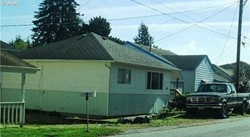 Brookings apartment for rent - A residential street with a house and a truck parked in front.