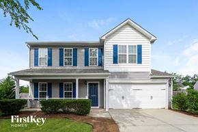 Whitsett house for rent - A two-story house with a garage and a blue door.