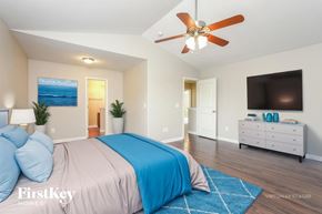 Whitsett house for rent - A bedroom with a bed, a ceiling fan, and a dresser.