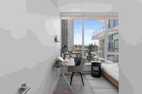 Coquitlam apartment for rent - A modern balcony with a table and chairs overlooking a cityscape.