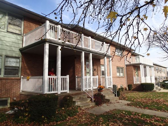 Shillington apartment for rent - A person is standing on the porch of a brick house.