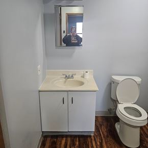 Lisbon apartment for rent - A bathroom with a toilet, sink and mirror.