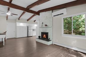 Belmont house for rent - A living room with a fireplace and wood floors.