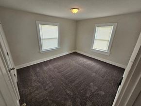 Lima apartment for rent - A room with grey carpet and two windows.