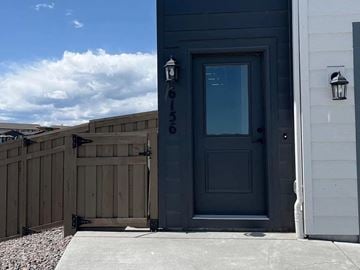Colorado Springs house for rent - A grey door with the number 6153 on it.