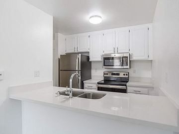 Van Nuys apartment for rent - A kitchen with white cabinets and appliances.