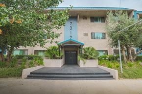 Van Nuys apartment for rent - A building with the number 3 on it is surrounded by greenery.