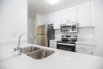 Van Nuys apartment for rent - A kitchen with a stainless steel sink and white cabinets.