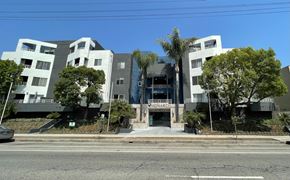 Reseda apartment for rent - A modern building with a glass entrance and a sign that reads "MONARCH".