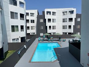 Reseda apartment for rent - A swimming pool in the middle of a courtyard surrounded by buildings.