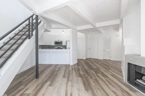Reseda apartment for rent - A modern living room with a staircase leading to the upper floor.