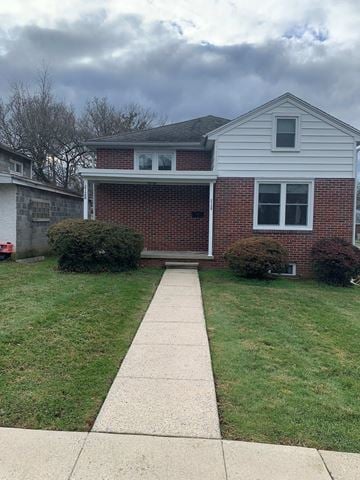 West Lawn house for rent - A house with a red brick wall and a white garage door.
