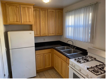 San Jose apartment for rent - A kitchen with wooden cabinets and a white refrigerator.
