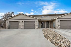 Sioux Falls house for rent - A house with a stone pathway leading to the garage doors.