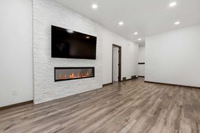 Sioux Falls house for rent - A modern living room with a fireplace and a flat screen TV mounted on the wall.