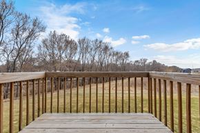 Sioux Falls house for rent - A wooden deck overlooks a grassy field.