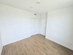 Surrey apartment for rent - A room with white walls and wood flooring with two doors.