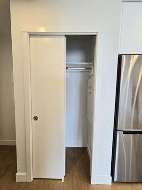 Surrey apartment for rent - A white door is open to reveal a small kitchen with a refrigerator.