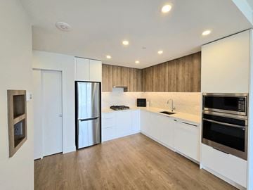 Surrey apartment for rent - A modern kitchen with white cabinets and stainless steel appliances.