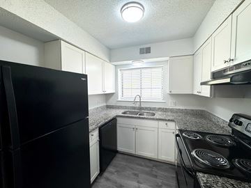 Columbia apartment for rent - A black refrigerator is in a kitchen with white cabinets.