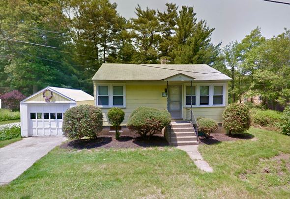 Randolph house for rent - A yellow house with a white garage door and a small porch.