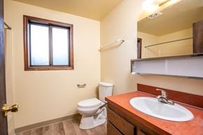 The Dalles apartment for rent - A bathroom with a toilet, sink, and mirror.