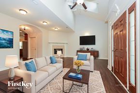 Murfreesboro house for rent - A well-lit living room with a couch, coffee table, and television.