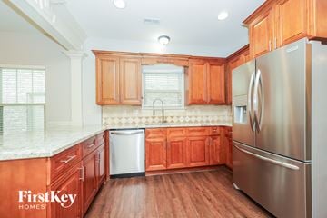 Murfreesboro house for rent - A kitchen with wooden cabinets and a stainless steel refrigerator.