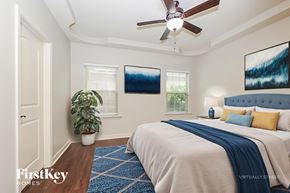 Murfreesboro house for rent - A bedroom with a bed, a ceiling fan, and a potted plant.