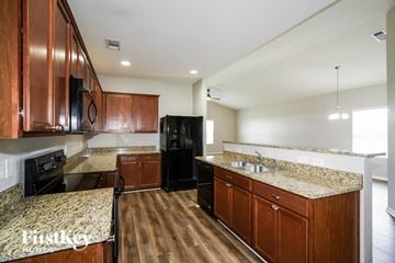 Murfreesboro house for rent - A kitchen with wooden cabinets and a granite countertop.