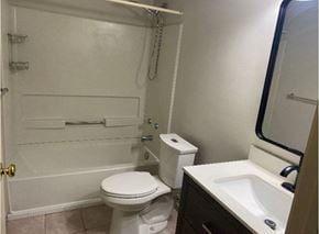 Kitchener house for rent - A white toilet sits next to a white sink in a small bathroom.