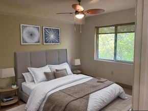 Kitchener house for rent - A bedroom with a large bed and a ceiling fan.