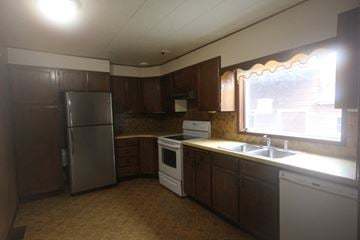 Whitefish apartment for rent - A kitchen with brown cabinets and a stainless steel refrigerator.