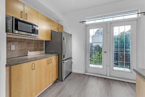 Calgary apartment for rent - A kitchen with wooden cabinets and a black refrigerator.